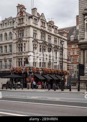 Das öffentliche Haus des Roten Löwen. Gäste außerhalb eines traditionellen englischen Pubs in der Parliament Street im Herzen des Londoner Stadtteils Whitehall. Stockfoto