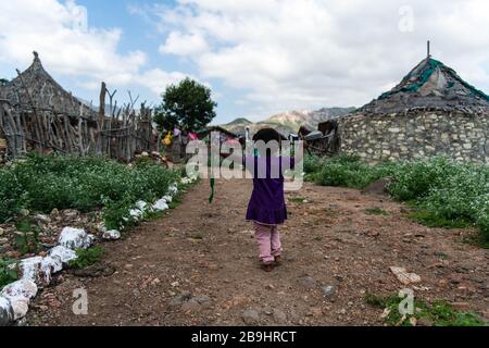 Afrika, Dschibuti, bankouale. Ein Kind spaziert in Bankouale in der Nähe traditioneller Hütten Stockfoto