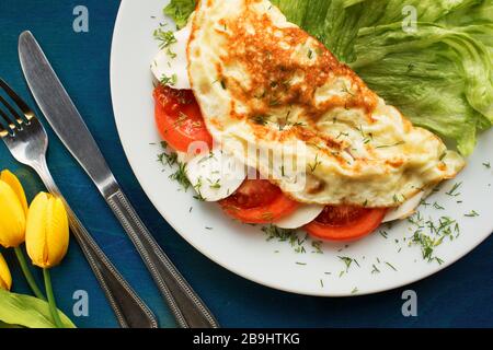 Farbenfrohes Omelette-Frühstück mit Mozzarella und Tomate Stockfoto