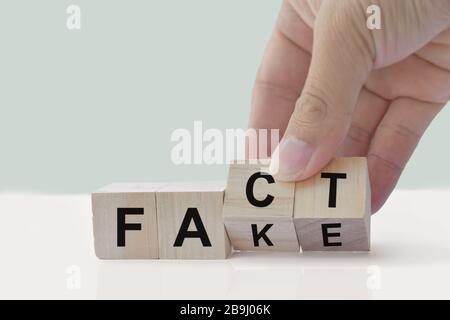 Hand Flip Holzwürfel verändern das Wort Fakt oder Fake. April schäumt Tageskonzept. Stockfoto