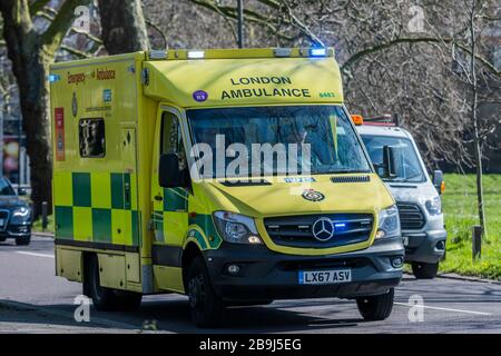 Clapham Common, London, Großbritannien. März 2020. Ein Krankenwagen übertrifft auf dem South Circular - dem ersten Tag der "Sperrung" in Clapham - einen nahezu normalen Verkehrsstand - den Ausbruch des Coronavirus (Covid 19) in London. Credit: Guy Bell/Alamy Live News Stockfoto