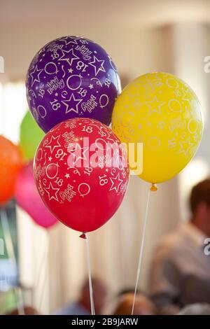 Drei bunte 18. Geburtstag Partyballons, rot, violett und gelb, auf einer Party Stockfoto