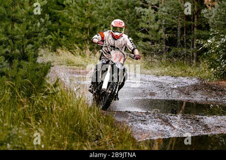 Motocross Enduro Rennsportler Motorradfahrer fährt auf einem Waldweg Stockfoto