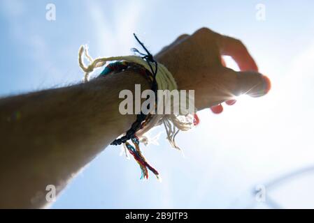 Hand mit hippigen Armreifen bei Sonnenschein. Fotografie von Danny Fitzpatrick www.dfphotography.co.uk danny@dfphotography.co.uk +44 (0) 7779 606901 Stockfoto