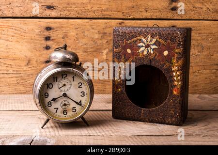 Antike Uhr mit geschnitztem Holzkasten über einem alten Vintage-Tisch - Kopierraum Stockfoto