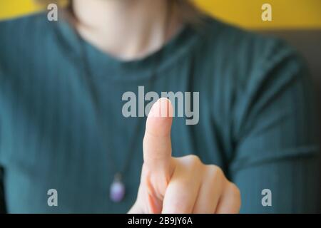 Mädchen hält Zeigefinger vor sich, zeigt auf Zuschauer und Kamera. Stockfoto