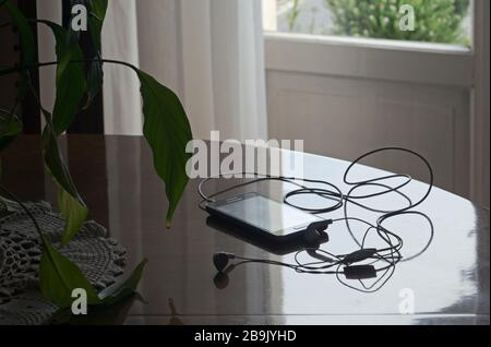 Smartphone mit Kopfhörern auf dem Tisch Stockfoto