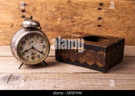 Antike Uhr mit geschnitztem Holzkasten über einem alten Vintage-Tisch - Kopierraum Stockfoto
