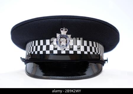 Real British Metropolitan Polizist Hut / Helm auf einfarbigem weißen Hintergrund mit Nahaufnahme Detail des Abzeichen Stockfoto