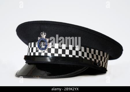 Real British Metropolitan Polizist Hut / Helm auf einfarbigem weißen Hintergrund mit Nahaufnahme Detail des Abzeichen Stockfoto