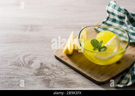 Zitronensorbet in Brille auf weißem Holztisch. Kopierbereich Stockfoto