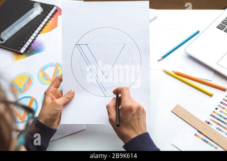 Der Designer zeichnet eine Skizze eines Markenlogos. Stockfoto