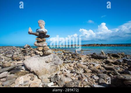 Gestapelte Felsen balancieren am felsigen Strand in Aruba Stockfoto