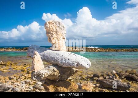 Gestapelte Felsen balancieren am felsigen Strand in Aruba Stockfoto