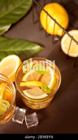 Glas kaltem Erfrischungstee mit Eis und Zitronenfrüchten Stockfoto