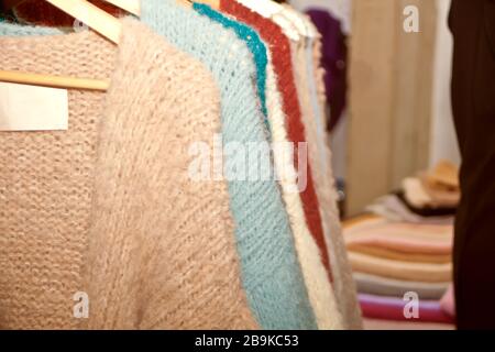 Sammlung warmer Pullover für Frauen, die auf einem Regal hängen. Stockfoto