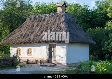 Traditionelles ukrainisches Lehmhaus mit Reetdach in Pirogovo, Ukraine. Stockfoto