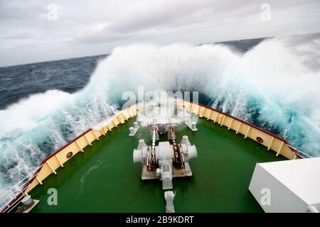 An einem stürmischen Tag stürzen die Aufbrecher auf das Deck eines Schiffes. Stockfoto