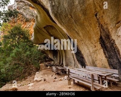 Bänke und Holztische entlang des Weges nach Cala Goloritzé, der zum berühmten Strand führt Stockfoto