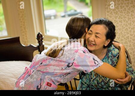 Die Krankenschwester lehnt sich an, um einer älteren Frau eine beruhigende Umarmung zu geben. Stockfoto