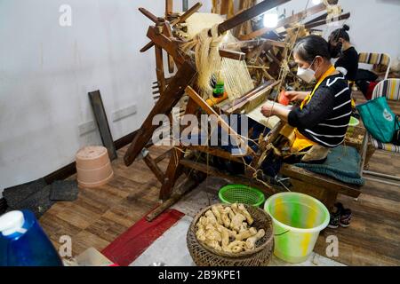 (200324) -- CHONGQING, 24. März 2020 (Xinhua) -- Frauen machen Rongchang Grass Linen, auch Rongchang Xiabu genannt, in einem Workshop im Rongchang District in Chongqing, Südwestchina, 23. März 2020. Rongchang Grass Leinen ist ein traditionelles chinesisches Handwerk mit einer reichen Geschichte. Es ist eine Art Tuch, das rein von Hand aus Ramie besteht und berühmt ist für seine weiche, dünne, flache Textur und feine Qualität. Da dieses Tuch den Körper normalerweise im heißen Sommer kühl hält, wird es auch Xiabu (wörtlich Sommertuch) genannt. Mit umfassenden epidemischen Präventionsmaßnahmen hat Xiabu, das Industrien hier macht, Res Stockfoto