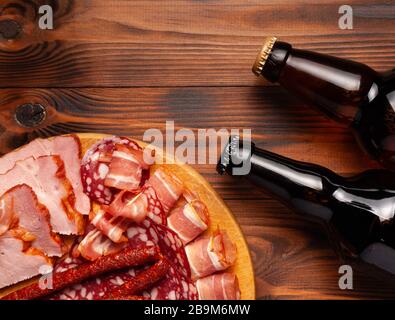 Bier-Imbiss in Form von Fleischprodukten und Flaschenbier. Vorspeise in Form von Speck, Salami, Schinken, Jagdwürsten. Stock Fotobier und Stockfoto