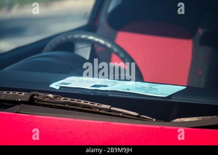 Blaue Plakette für Behinderte Parkaufkleber auf der Windschutzscheibe des Autos Stockfoto