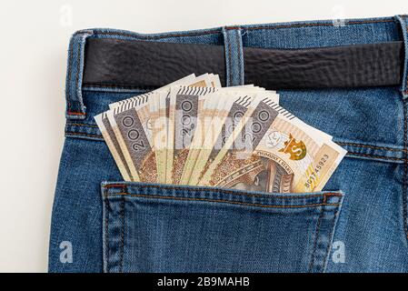 Viele polnische Banknoten mit einem Nennwert von 200 PLN sind in die hintere Tasche der blauen Jeans-Hose gesteckt. Stockfoto