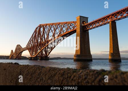 Die Forth Rail Bridge, die bei Sonnenuntergang den Firth of Forth überquert, Edinburgh, Schottland. Stockfoto