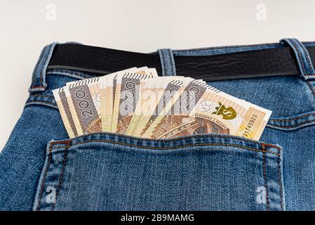 Viele polnische Banknoten mit einem Nennwert von 200 PLN sind in die hintere Tasche der blauen Jeans-Hose gesteckt. Stockfoto