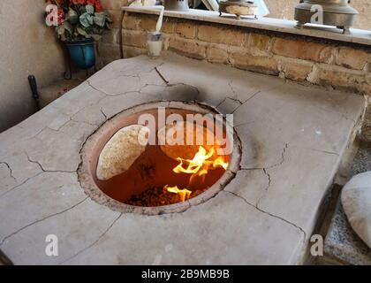 Brotbacken im traditionellen Tandoor Ofen im Khaneye Amoo Mash Reza Haus (Haus des Onkels Mesh Reza) im Dorf Kavirabad, Varamin, Teheran Stockfoto