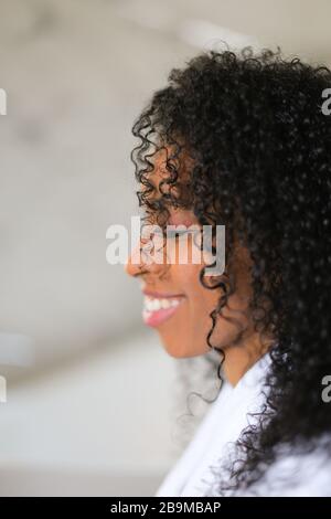 Porträt eines lächelnden schwarzen, lockig behaarten Mädchens. Stockfoto