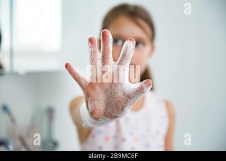 Kleines Mädchen waschen die Hände mit Wasser und Seife im Badezimmer. Handhygiene und Vorbeugung von Virusinfektionen. Stockfoto