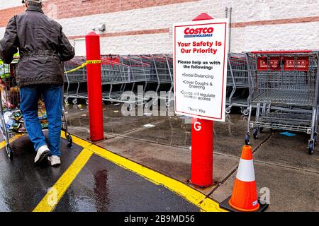 Sterling, USA - 23. März 2020: Kunden- und Einkaufswagen beim Eintritt in den Costco Discount-Mitgliedschaftsclub Store während Coronavirus Covid-19 Out Stockfoto