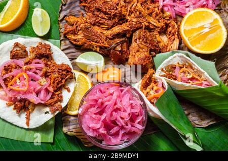 Cochinita Pibil, mexikanische, pit-geröstete Schweineform aus Yucatan, auf Bananenblättern mit traditionellen Gewürzen. Tacos und Tostadas aus Mexiko. Stockfoto