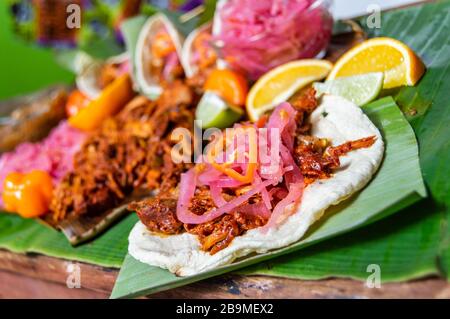 Cochinita Pibil, mexikanische, pit-geröstete Schweineform aus Yucatan, auf Bananenblättern mit traditionellen Gewürzen. Tacos und Tostadas aus Mexiko. Stockfoto