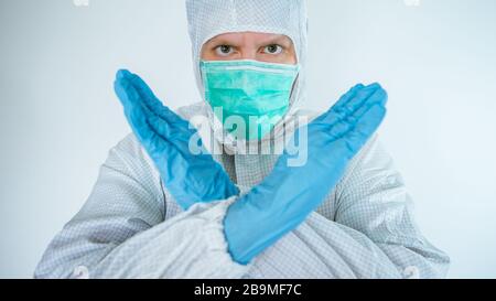 kaukasischer Arzt, der einen Schutzanzug und eine Schutzmaske trägt, eine Stopp-Zeichen-Geste macht und die Zahl der Verweigerung der Viruserkrankung signalisiert, Nahaufnahme. Isoliert auf weiß Stockfoto