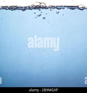 Blaue Wasseroberfläche mit Blasen auf der Oberfläche. Klares Wasser. Unterwasseraufnahmen. Hintergrund mit Platz für Ihren Text. Stockfoto