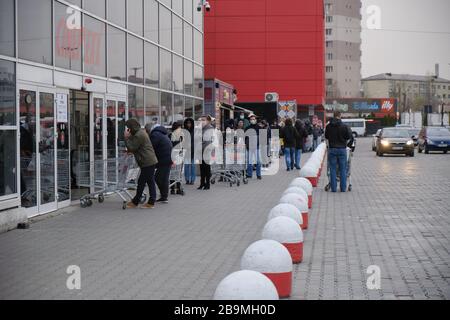 Bukarest, Rumänien - 24. März 2020: Käufer stehen in einer Warteschlange vor einem Supermarkt, nachdem ein Coronavirus Lockdown angekündigt wird. Stockfoto