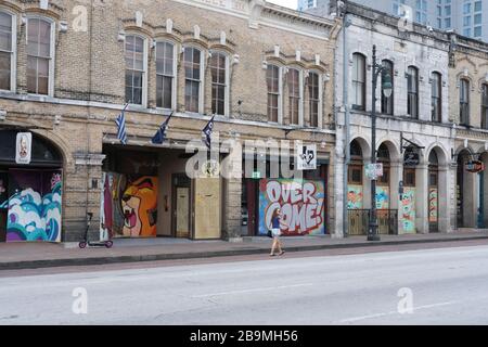 Austin, Texas, USA. März 2020. Ein Passant, der vorbei geht, ist über Fenster in der Sixth Street in Austin, TX, eingestiegen. Die Bretter wurden am Dienstagmorgen bemalt. Austin-Bürgermeister Steve Adler ordnete an, dass die Stadt "Day Home, Work Safe" Dienstag bis 13. April um 23:59 Uhr in Betrieb ist. Credit: Jordan Sigler/Alamy Live News Stockfoto