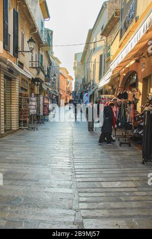 Alcudia, Mallorca, Spanien - 22. März 2018: Ein paar Menschen, die in den Straßen der Altstadt von Alcudia spazieren gehen Stockfoto