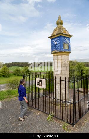 Person, die Informationszeichen an der Säule der Gräfin, Brougham, Cumbria, England, Großbritannien liest Stockfoto