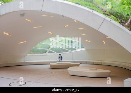 Frau liest ein Buch in einem grünen, modernen Pavillon im Park des Musée du Quai Branly. Ökologische Architektur. Reisestandorte in Frankreich. Stockfoto