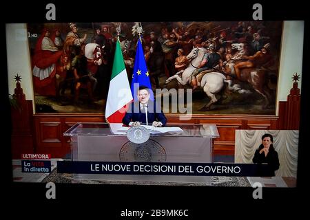 Turin, Italien. März 2020. TURIN, ITALIEN - 24. März 2020: Der Fernsehsender Rai 1 sendet die Video-Pressekonferenz des italienischen Premiers Giuseppe Conte und kündigt neue Maßnahmen für den Coronavirsu-Notfall an. Die italienische Regierung hat beispiellose Einschränkungen auferlegt, um die Ausbreitung des COVID-19-Coronavirus-Ausbruchs zu stoppen, und andere Maßnahmen, die die Bewegungen der Menschen nur für die Arbeit, für den Kauf wesentlicher Waren und aus gesundheitlichen Gründen erlaubt sind. (Foto von Nicolò Campo/Sipa USA) Credit: SIPA USA/Alamy Live News Stockfoto