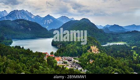 Schloss Hoehenschwangau mit Alpsee links und Schwansee rechts und Alpen im Hintergrund. Stockfoto