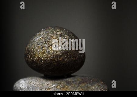 Kleiner Rock mit Goldflecken auf einem anderen Rock Close Up Photo Stockfoto