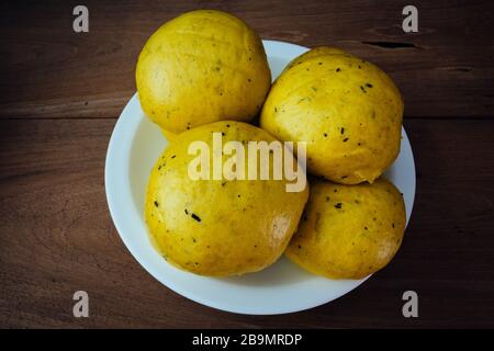 Mantou (traditionelles Chinesisch: 饅頭), chinesische/orientalische gedämpfte Brötchen aus Kürbisfleisch, verzehrfertig, hausgemacht. Natürlich und schön goldgelb Stockfoto