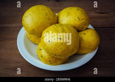 Mantou (traditionelles Chinesisch: 饅頭), chinesische/orientalische gedämpfte Brötchen aus Kürbisfleisch, verzehrfertig, hausgemacht. Natürlich und schön goldgelb Stockfoto