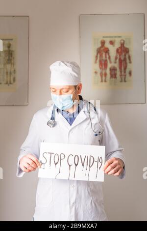 Arzt hält Stoppschild Stopp COVID-19 konzeptionelles Bild. Stockfoto