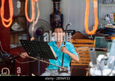 Mann spielt Erhu Traditionelles chinesisches Saiteninstrument Chengdu Street Market China Stockfoto